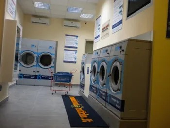Interno di lavanderia con lavatrici e asciugatori